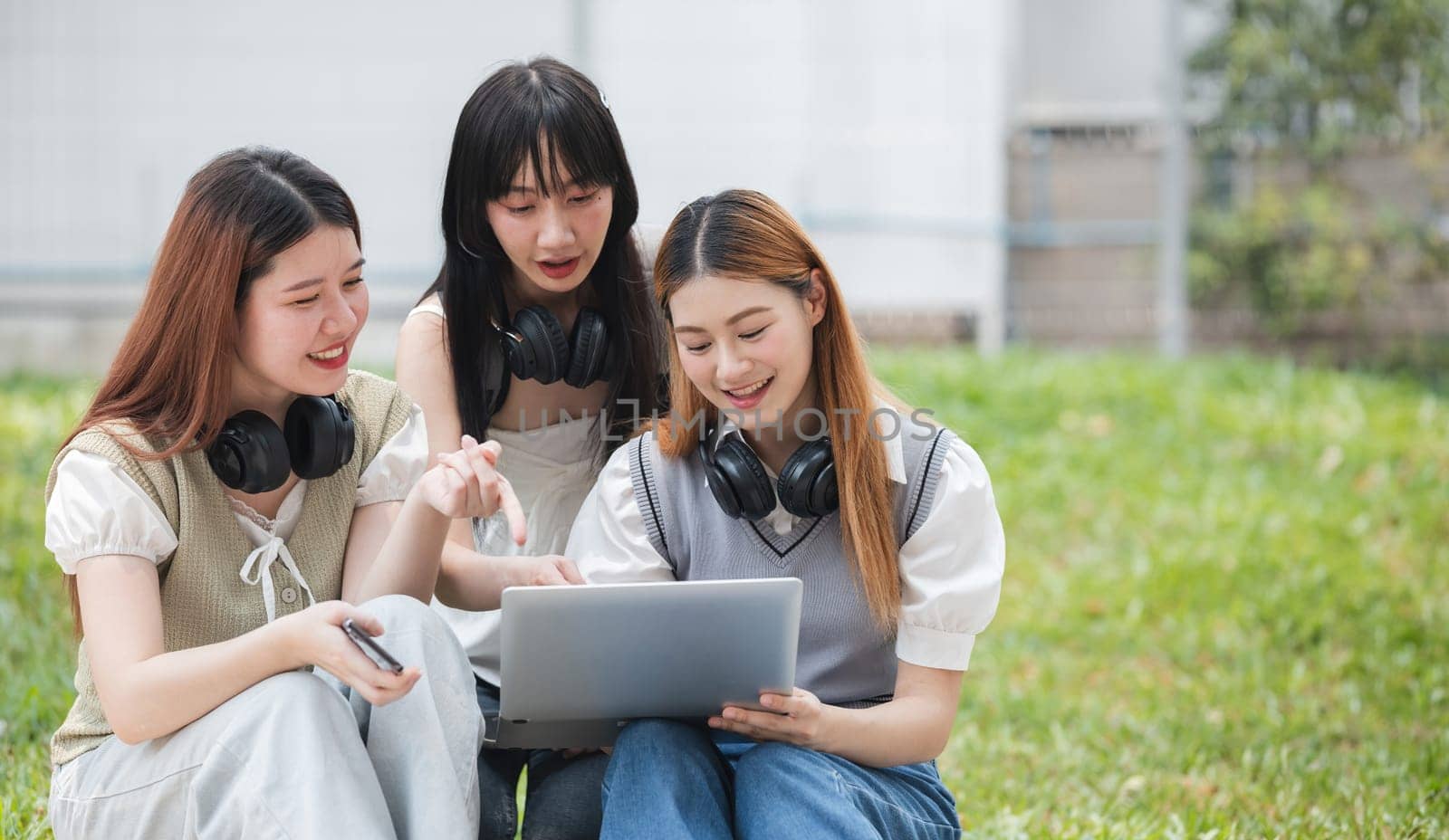 Group Of Young Asian Students Collaborating Outdoors at University. Teamwork and Knowledge Sharing. Asian Students Engaged in Collaborative Learning Outdoors. by wichayada