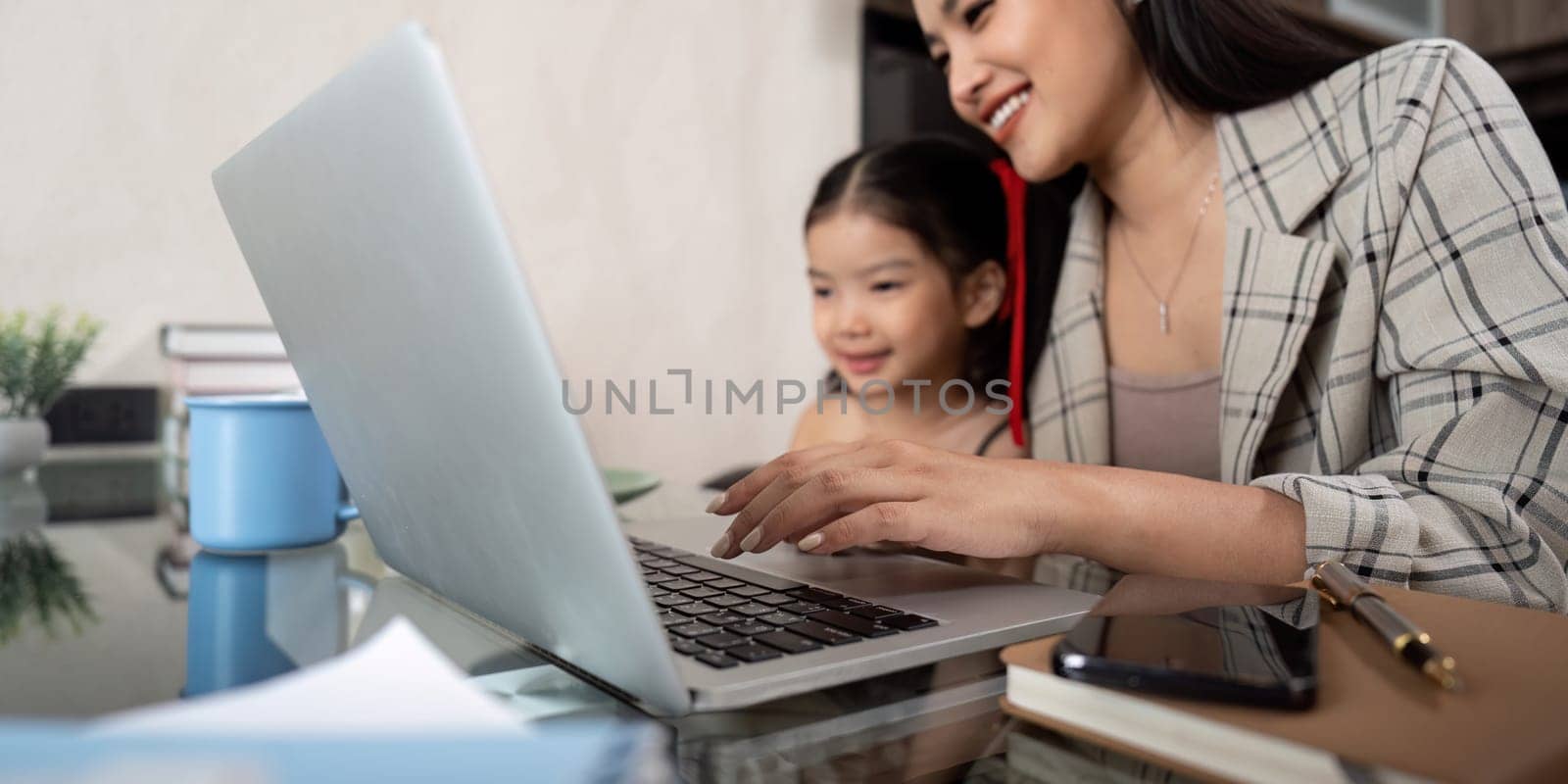 Working mom work from home office. businesswoman and cute child using laptop work freelancer workplace in home, Lifestyle family moment.