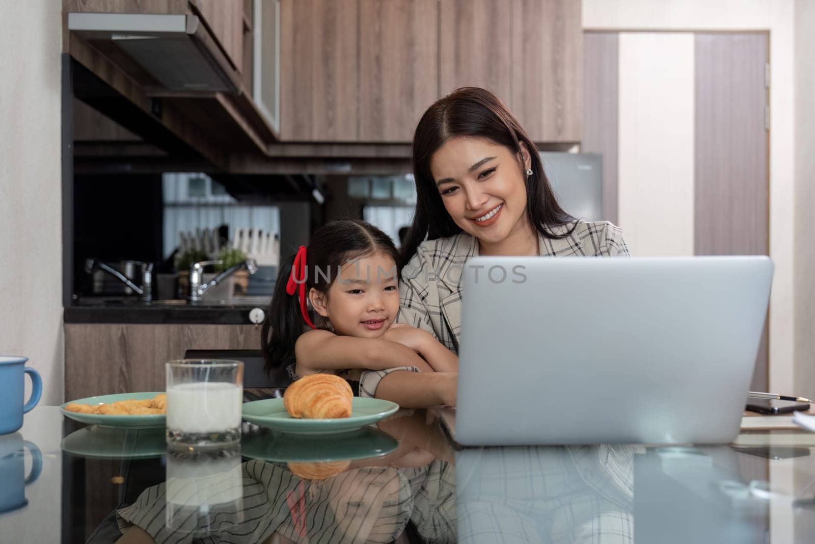 Working mom work from home office. businesswoman and cute child using laptop work freelancer workplace in home, Lifestyle family moment by nateemee