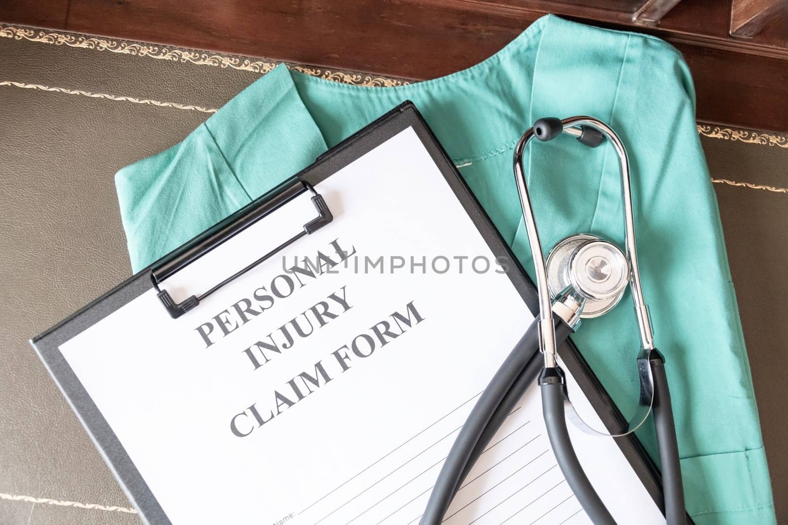A personal injury claim form on a clipboard, accompanied by a stethoscope and medical scrubs, indicating health-related legal action. by jbruiz78