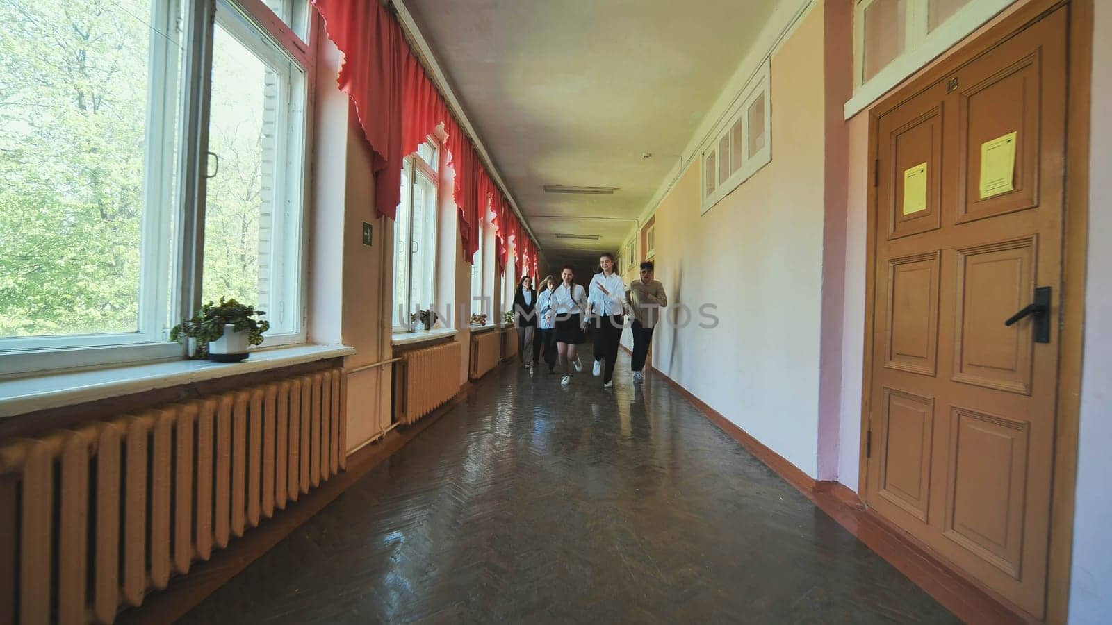 The students are running down the hallway of the school. by DovidPro