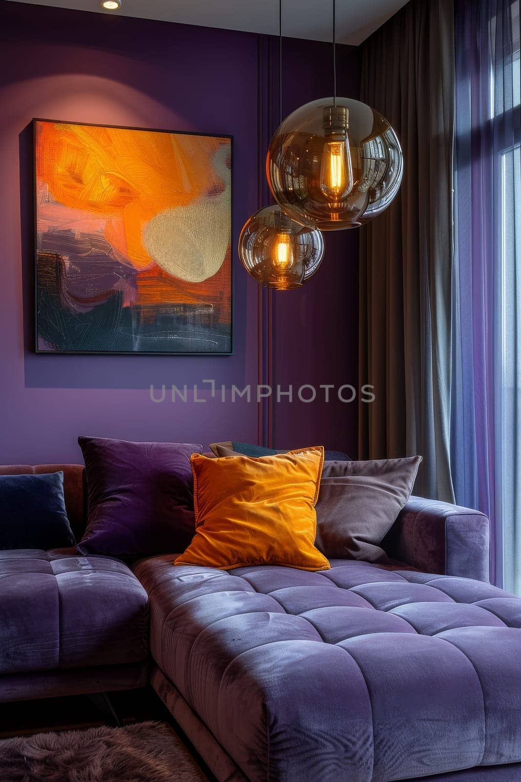 A purple couch with pillows and a painting on the wall. The couch is covered in purple velvet and has a large pillow on it. The painting on the wall is abstract and colorful