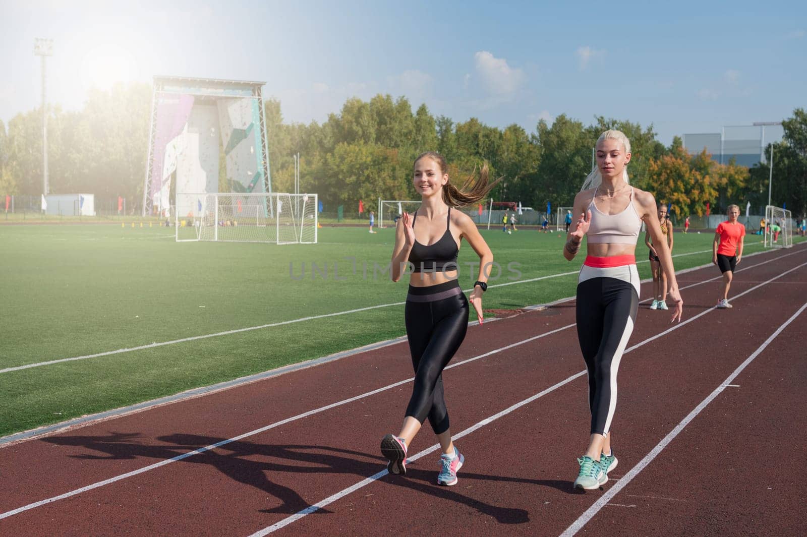 Two athlete young woman runner at the stadium by rusak