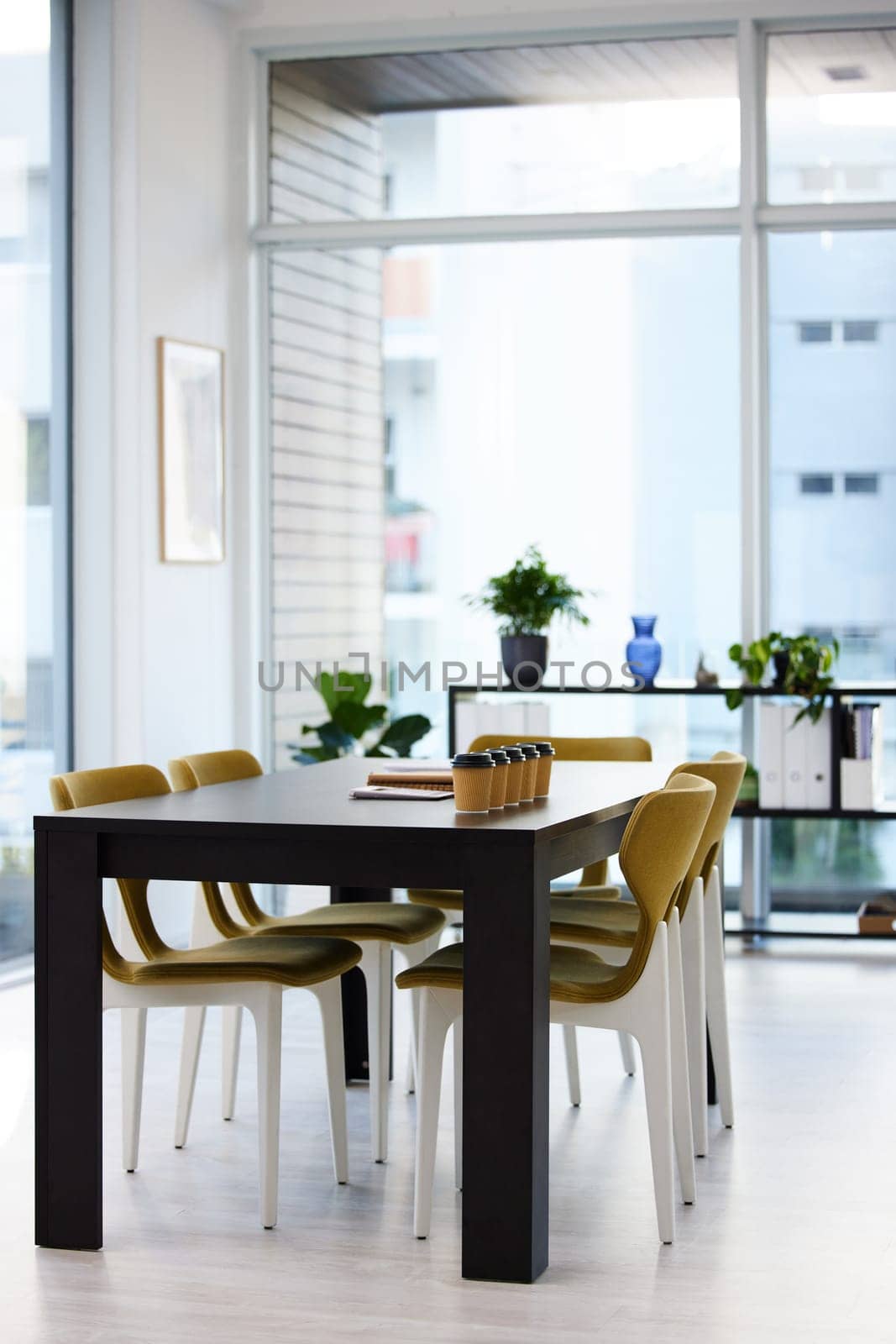 Empty office, meeting room and coffee cup on table with paperwork, seminar setup or advisory business workshop. Notebook, workspace and furniture in boardroom at consulting agency for conference.