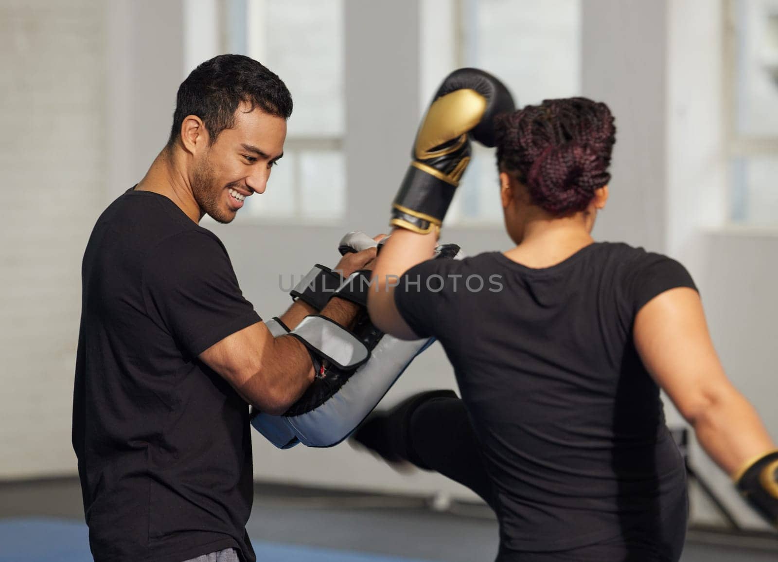 Boxer, woman and trainer with boxing gloves for fight workout of muay thai exercise. Fitness coach, self defence and sport pads for strength and power training in gym with cardio and instructor.
