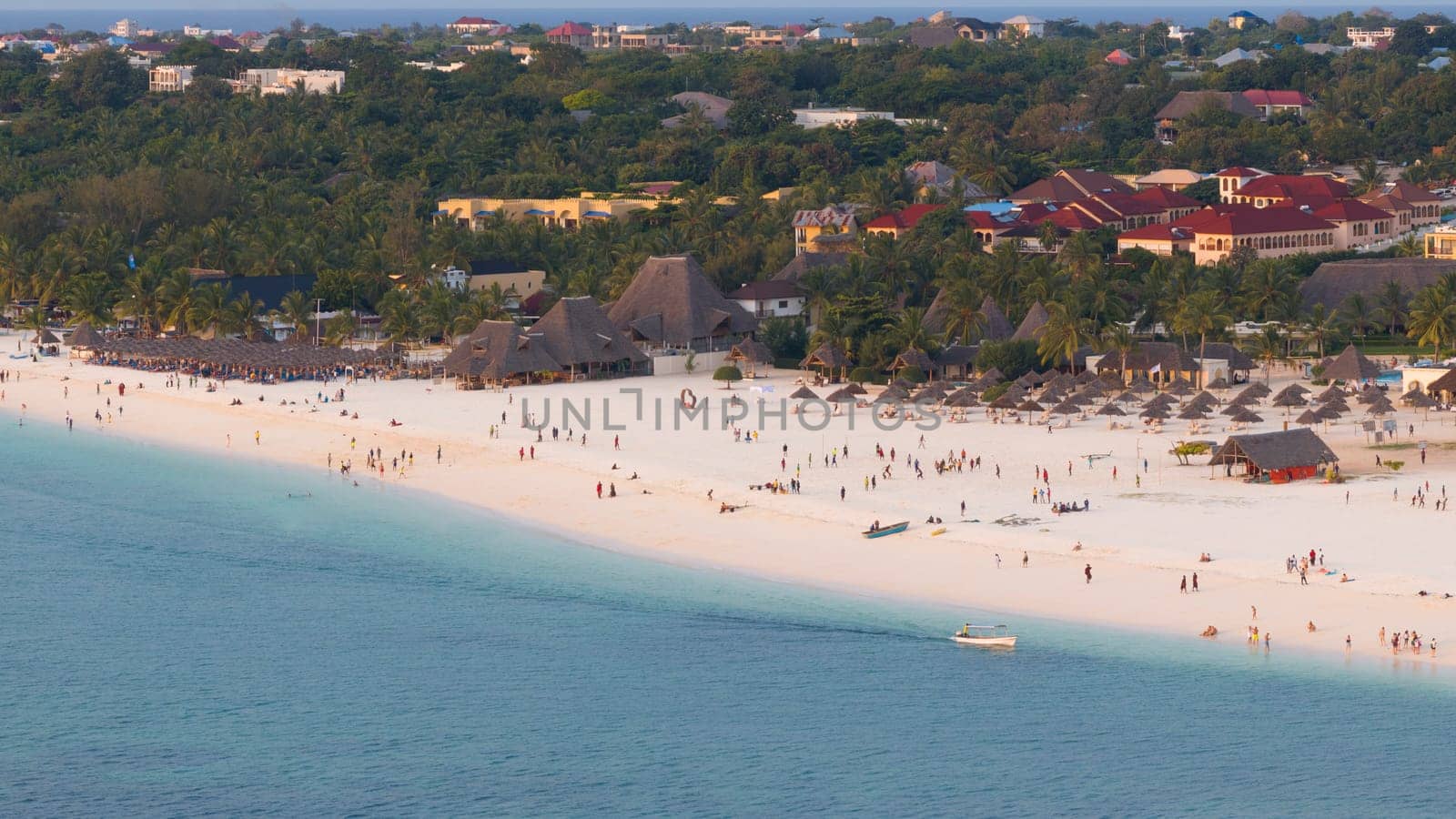 Kendwa beach with a lot of people and a boat in the water. Scene is relaxed and fun, summer concept, Tanzania, Zanzibar