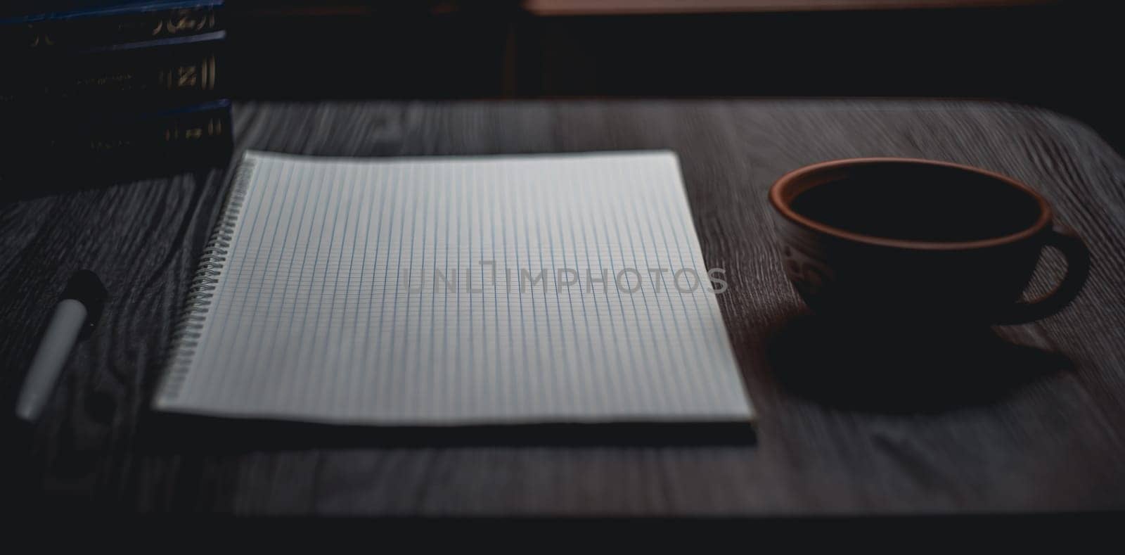 Workplace. Notebook with black marker and coffee mug on wooden table. High quality photo