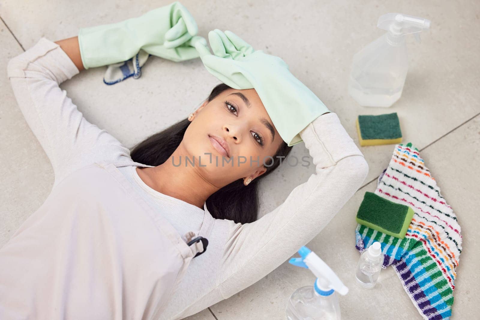 Cleaning, portrait and woman in home with above for fatigue and relaxing for housework, tired and frustrated. Girl, ground and bored with supplies for housekeeping, burnout and exhausted for working