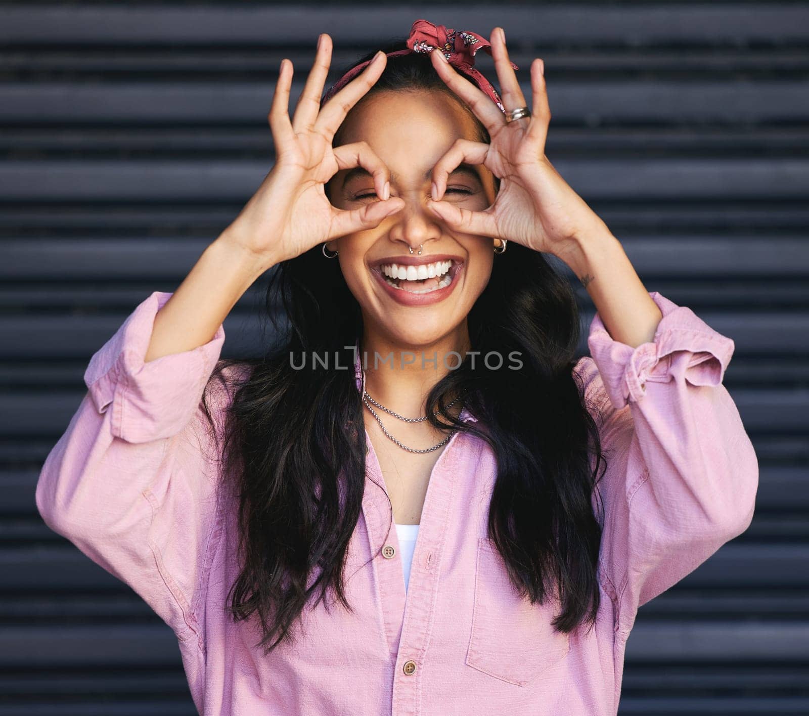 Excited, smile and woman with hands for okay sign, urban fashion and laugh at garage door. Happiness, gen z female person and streetwear with perfect gesture, confident and emoji on dark background by YuriArcurs