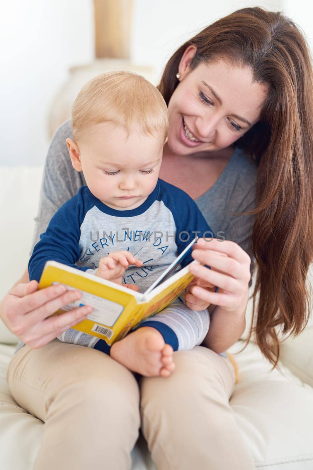 Mother, child and book for development, growth and education in childhood as baby at home. Woman, toddler and play for learning, reading and support in living room for cognition, bonding or curiosity by YuriArcurs