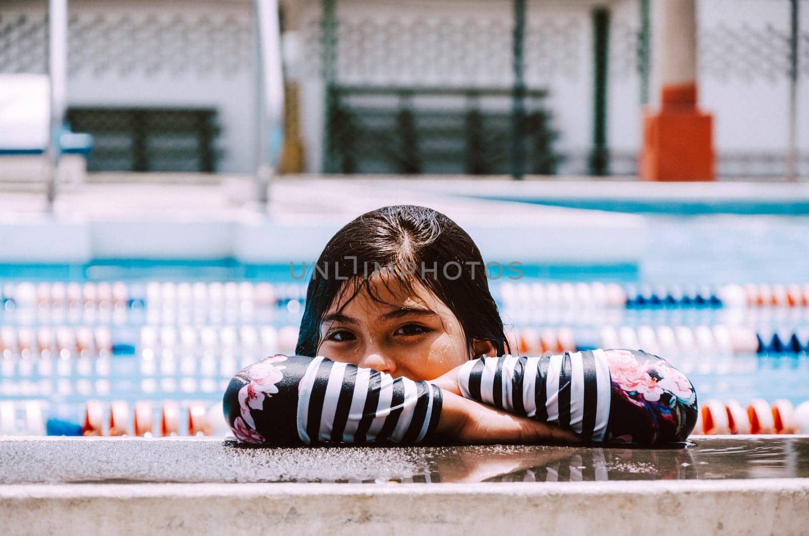 Portrait of a smiling girl in the pool. by Peruphotoart