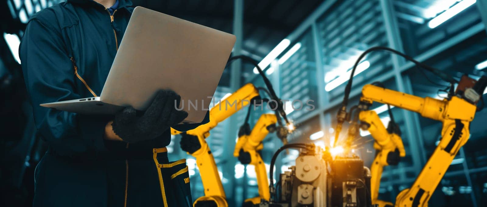 MLB Engineer use advanced robotic software to control industry robot arm in factory. Automation manufacturing process controlled by specialist using IOT software connected to internet network.