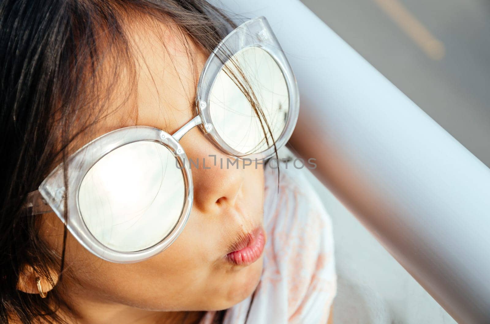 Happy little girl with big sunglasses looking at the sun. by Peruphotoart