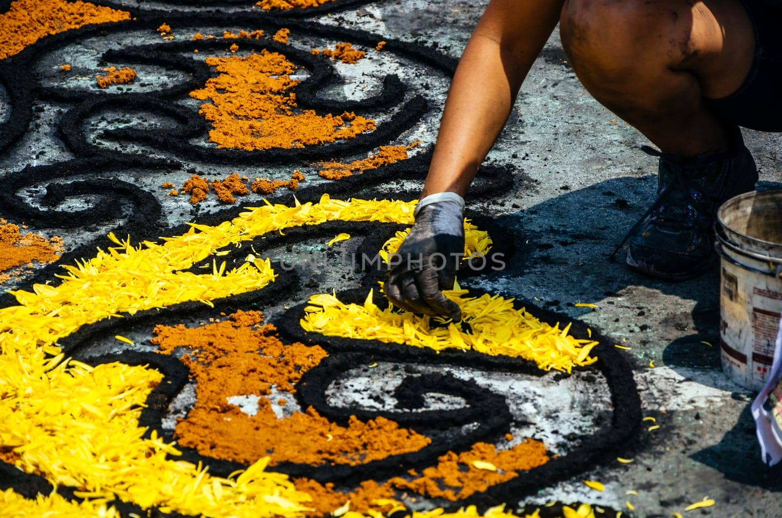 Closeup of a skilled artisan handcrafting an intricate floral pattern using yellow petals for an Easter festival in Lima - Peru