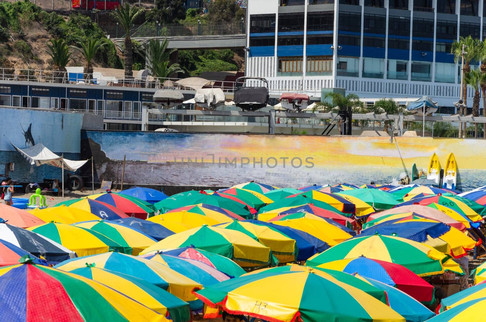 Colorful umbrellas on the beaches of the coast of Lima, Peru. by Peruphotoart