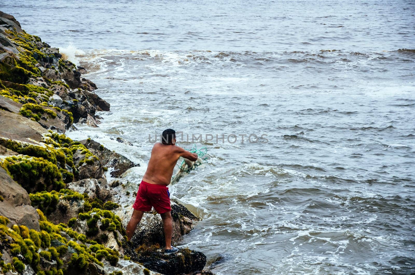 Fisherman pulling fishing net on the beaches of Lima, Peru. by Peruphotoart