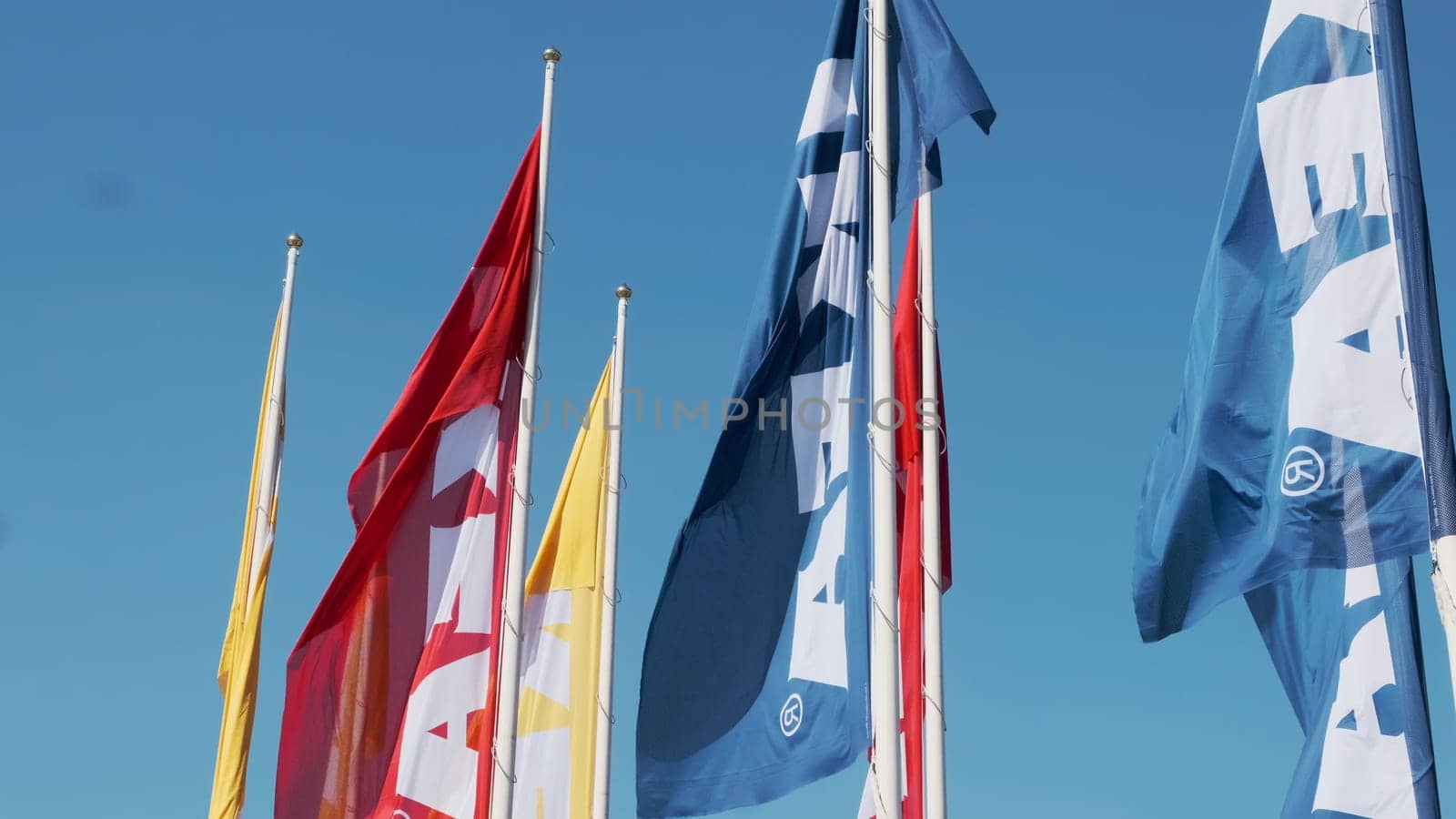 Colorful IKEA flags waving the wind against sky, July 2022, Prague, Czech Republic.