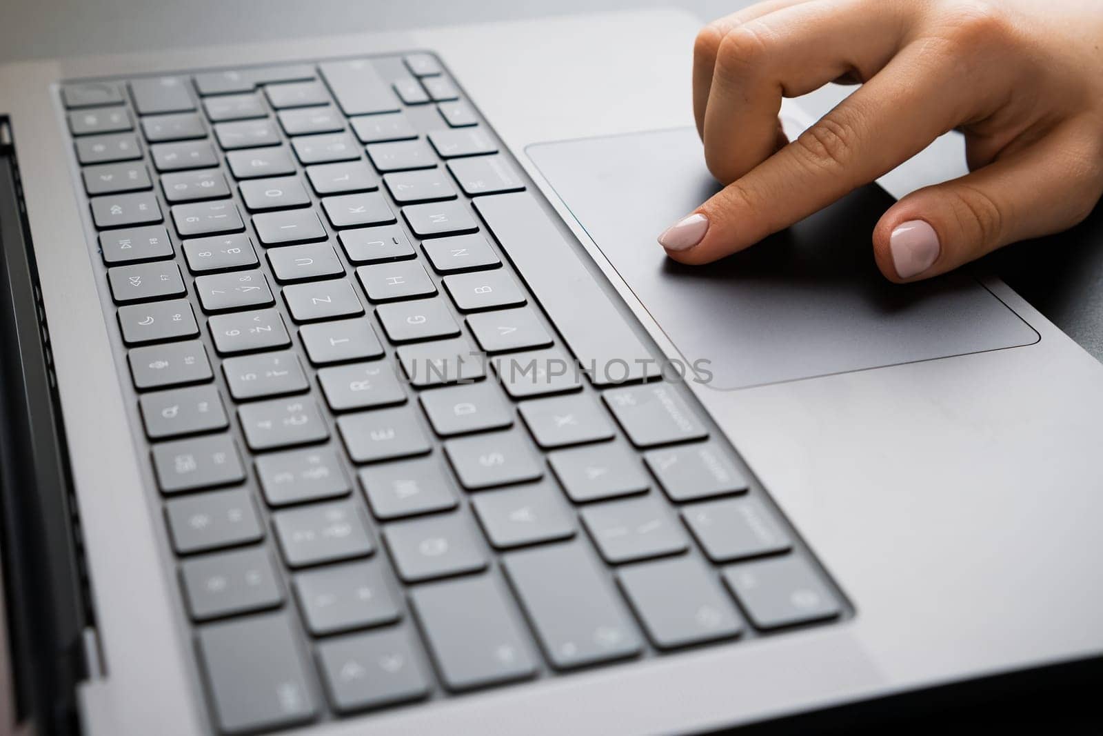 BERLIN, GERMANY - APRIL 14 2024: Female hand working on a computer touchpad. Business office workplace concept.