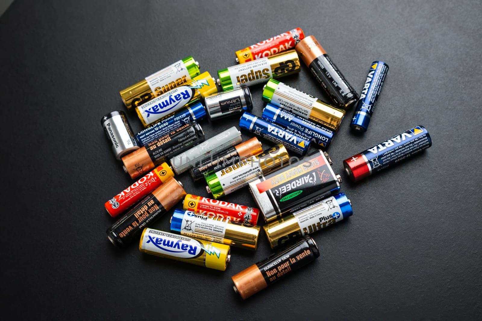 BERLIN , GERMANY - APRIL 14 2024: AAA, AA, CR2, 9 Volt used alkaline batteries on the black table.