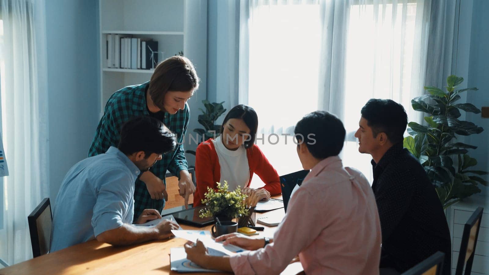 Business woman walking and hold tablet to present marketing plan to group of investor. Creative startup team discussing about financial graph and waving hand to greeting project manager. Convocation.