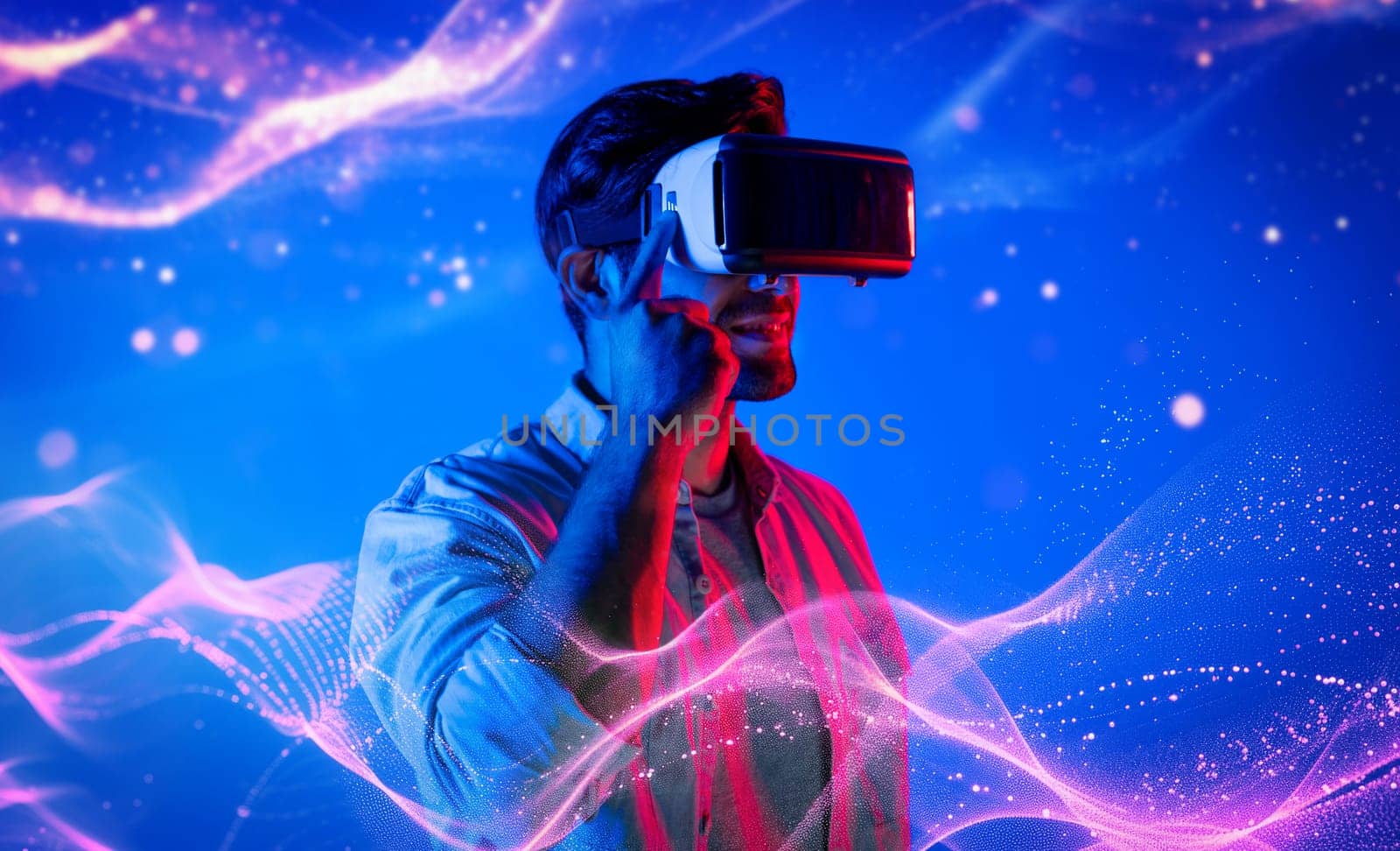 Smart caucasian man wearing VR glasses while standing at neon light. Deviation. by biancoblue
