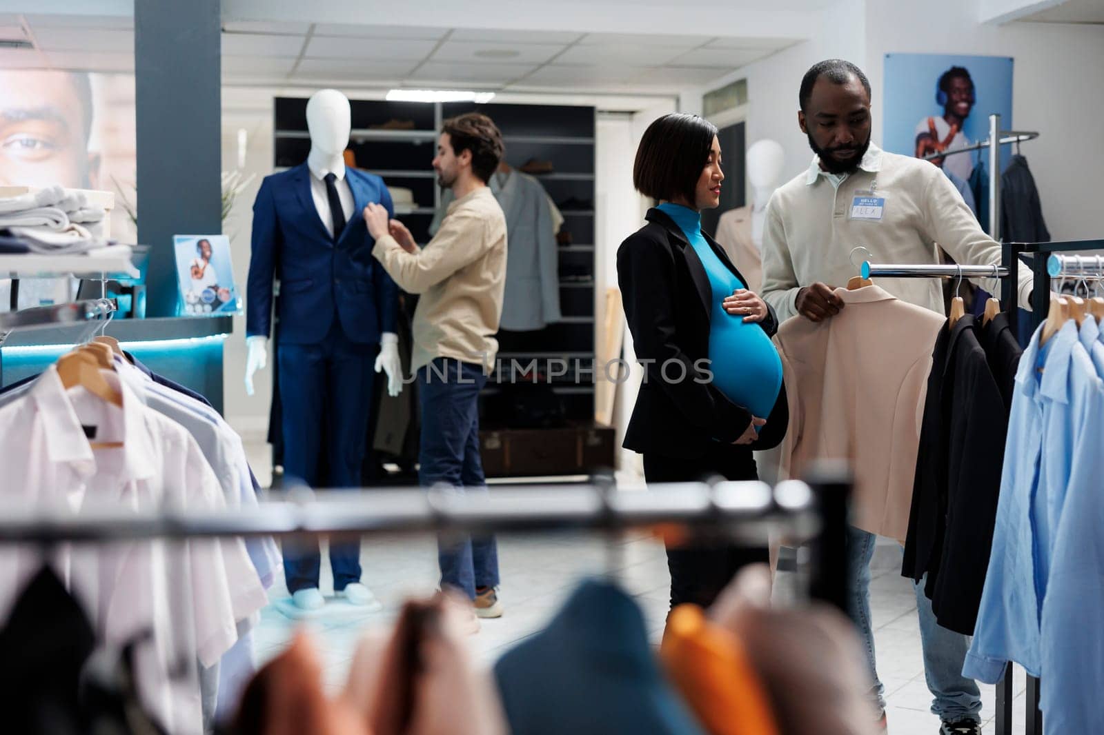 Pregnant customer selecting jacket by DCStudio