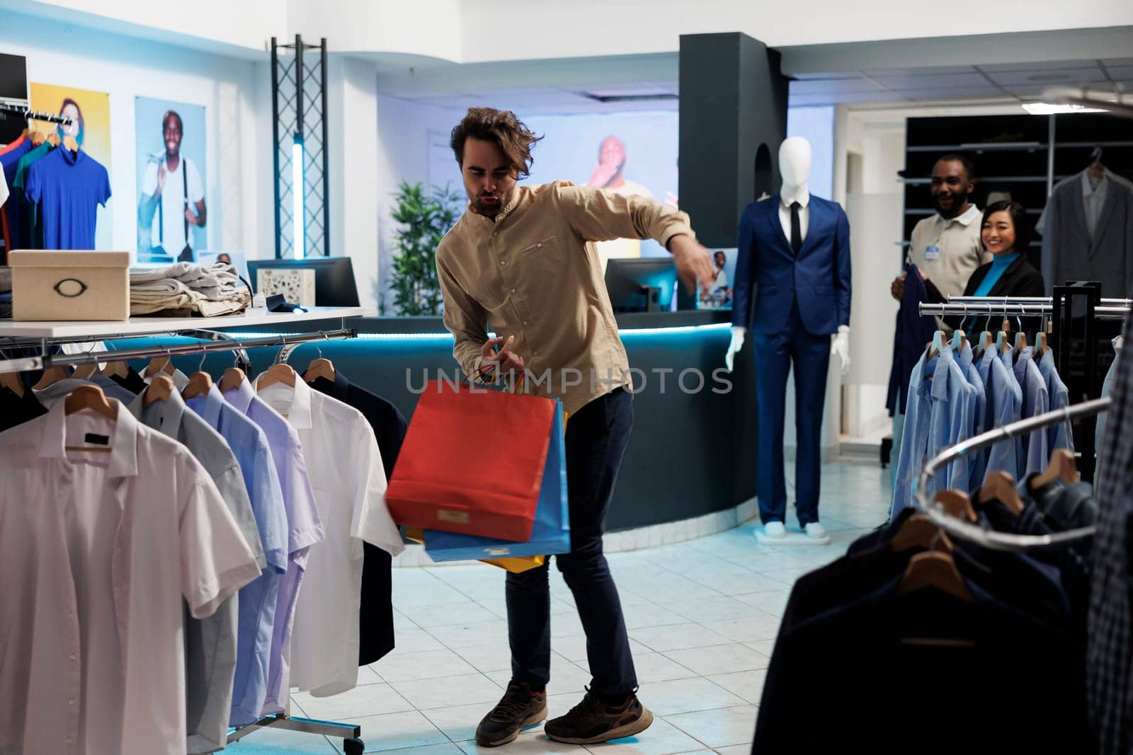 Man dancing with bags in shopping center by DCStudio