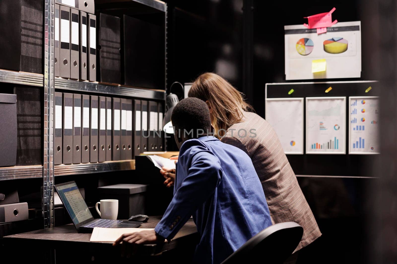 Depository employees working overhours at bureaucracy record, analyzing administrative report in storage room. Diverse bookkeepers checking accountancy files, organizing corporate documents