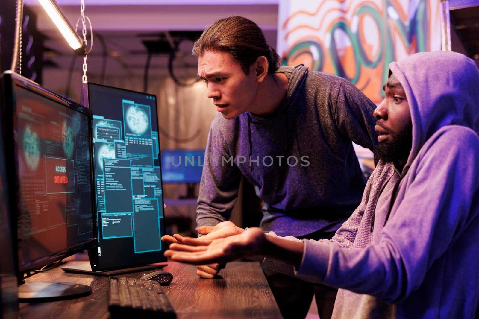 Disappointed hackers failing to break into server while looking at access denied message on computer screen. Angry unhappy criminals unsuccessfully hacking database cybersecurity system