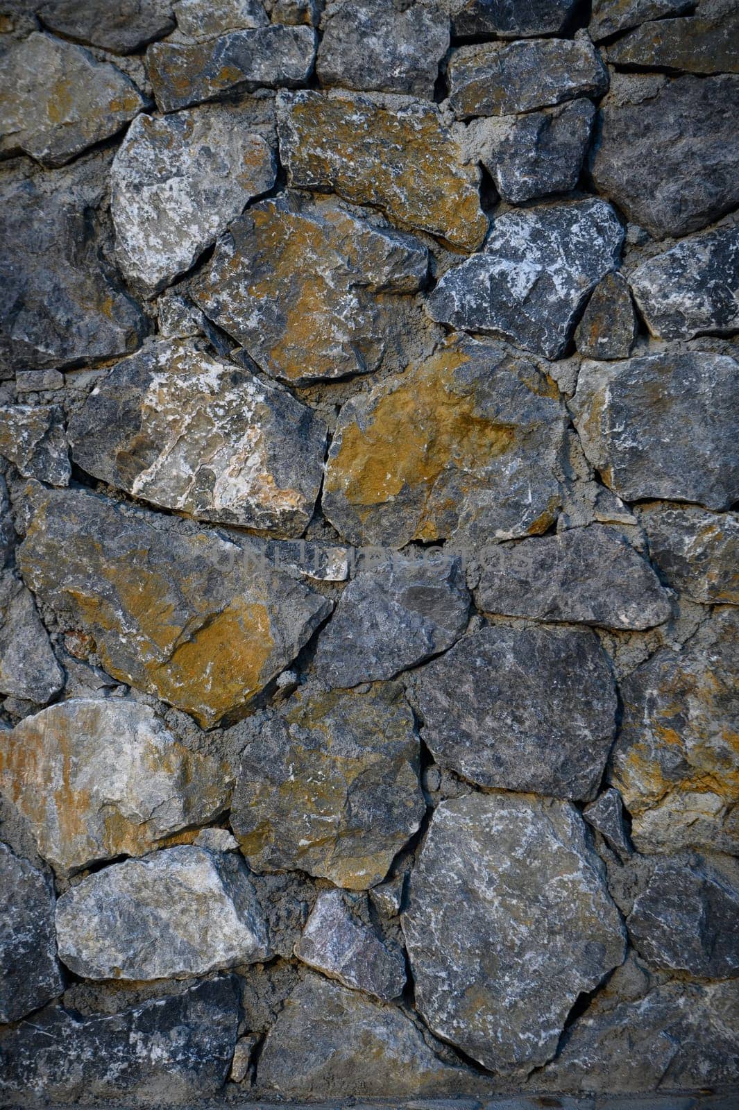 Granite stones of different shapes and colors. Wall cladding. Background selective focus with copy space. 2 by Mixa74