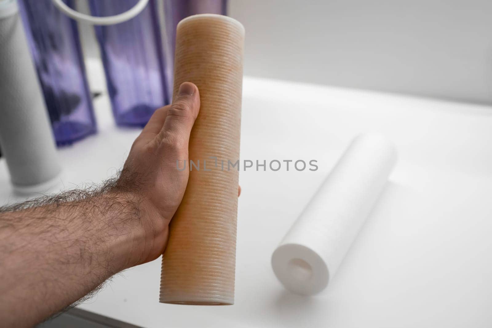 Man replacing dirty filter for reverse osmosis in the kitchen. Purification water concept.