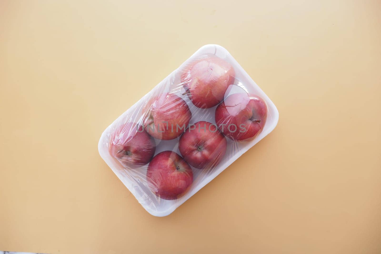 apples wrapped in transparent plastic .