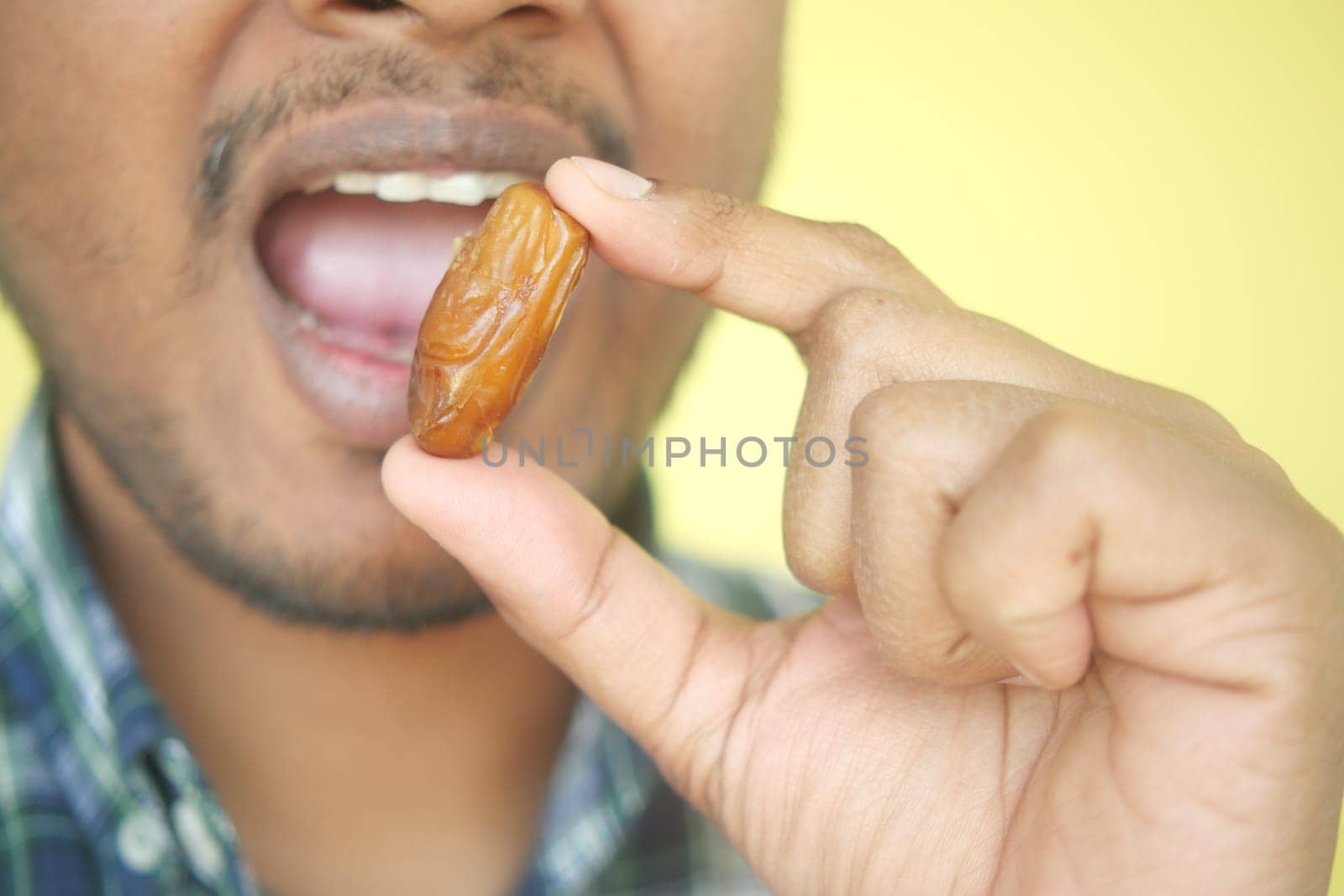 Close up of hand holding a date fruit .