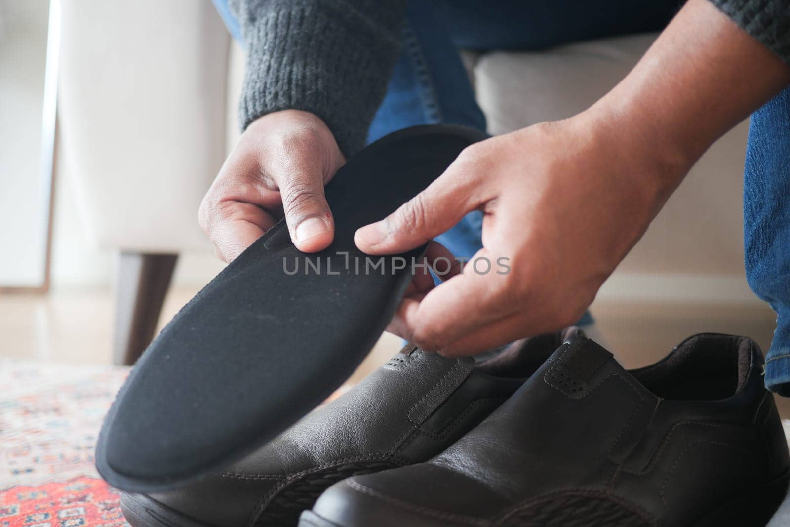 men hand putting Orthopedic insoles in shoes .