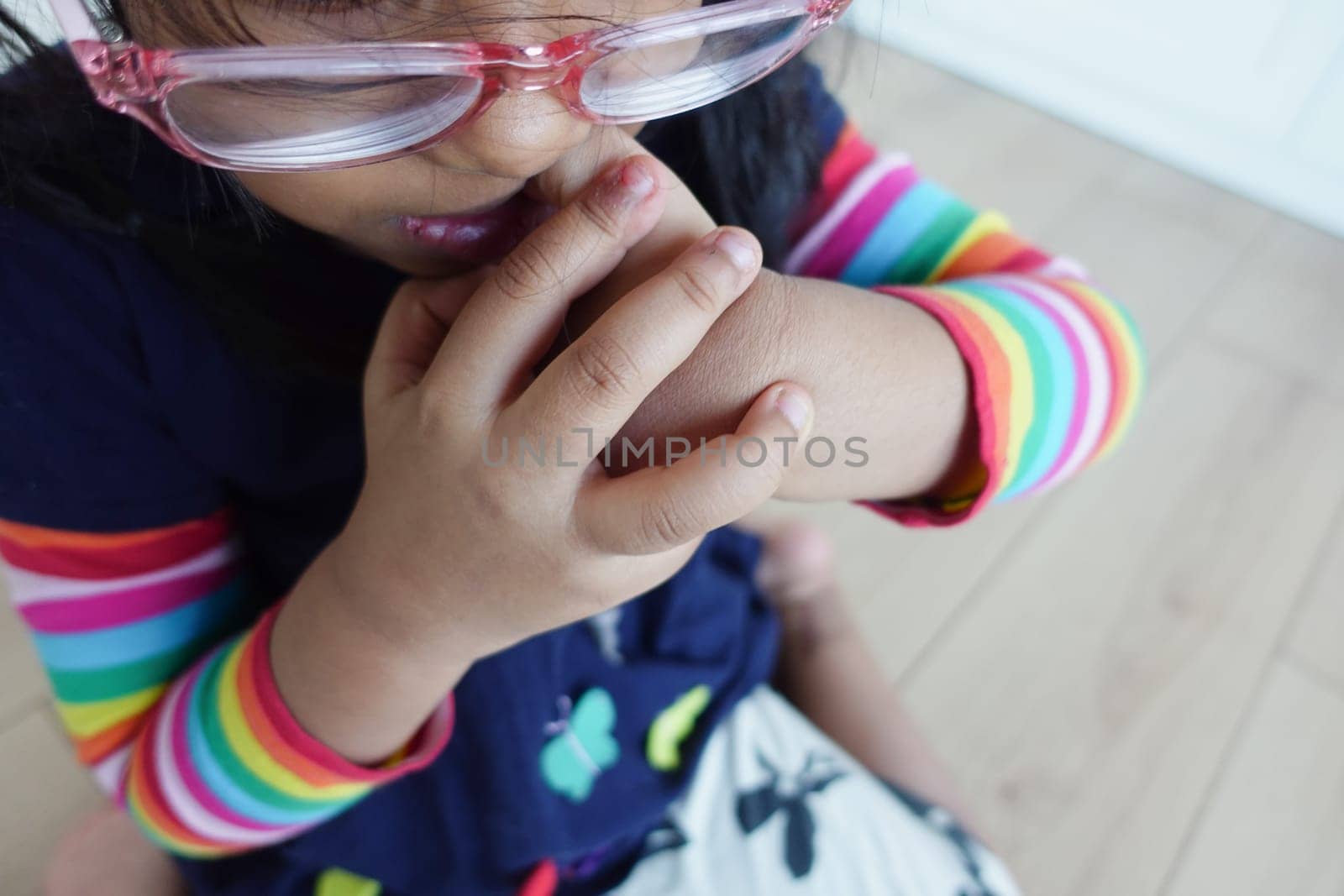 child girl biting her nails at home