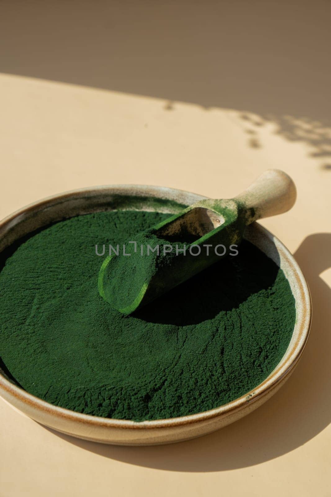 Organic blue-green algae spirulina powder food in plate with wooden spoon. Copy space for your text Health benefits of spirulina chlorella. Vitamins and minerals to diet. Detox dietary supplement Seaweed superfood by anna_stasiia