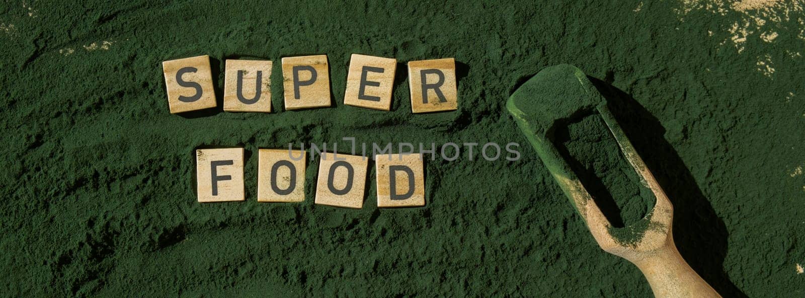 Wooden blocks with text SUPERFOOD chlorella on background of algae superfood powder. Healthy benefits supplement and vegan antioxidant healthy eating by anna_stasiia