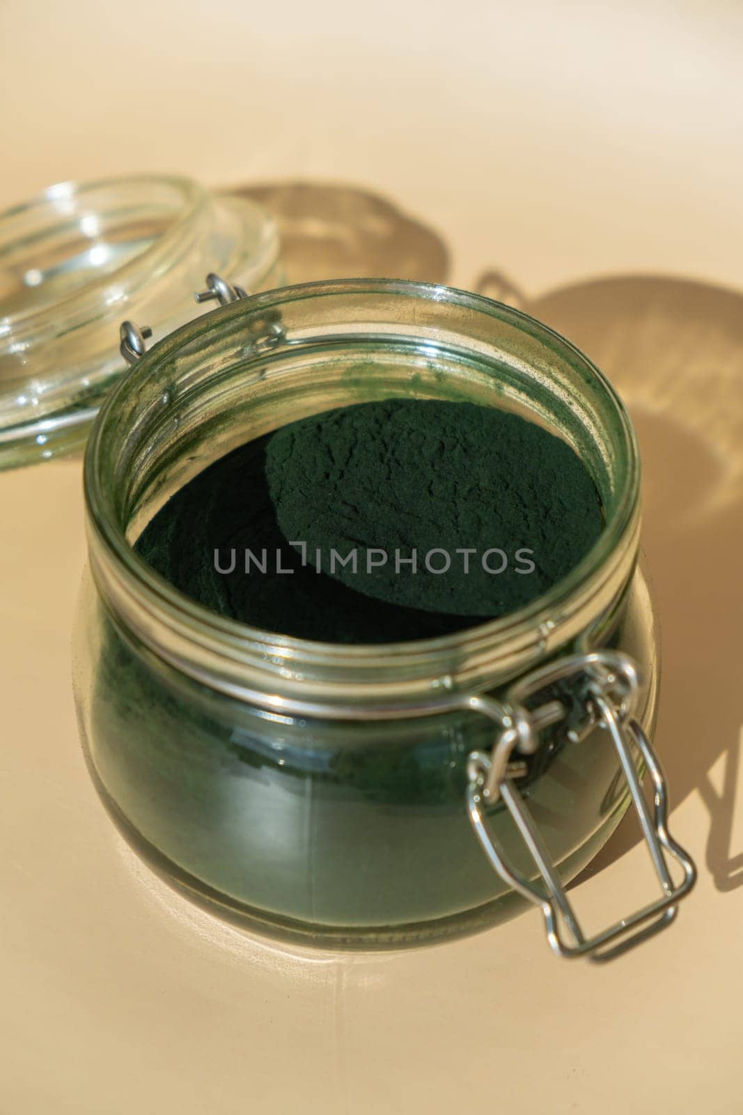 Organic blue-green algae spirulina powder food in glass jar. Health benefits of spirulina chlorella. Dietary supplement superfood concept