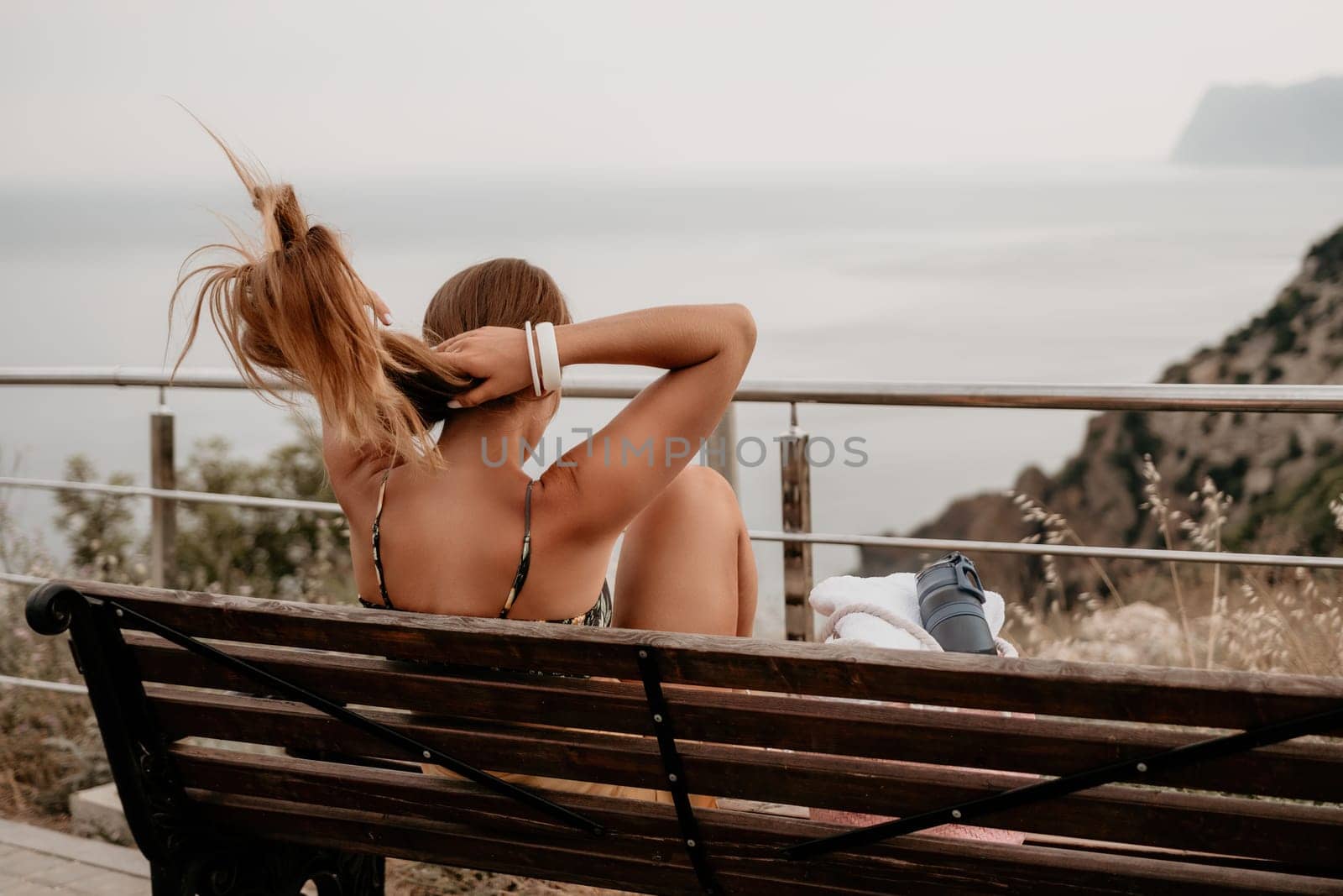 Woman travel sea. Happy tourist taking picture outdoors for memories. Woman traveler looks at the edge of the cliff on the sea bay of mountains, sharing travel adventure journey.