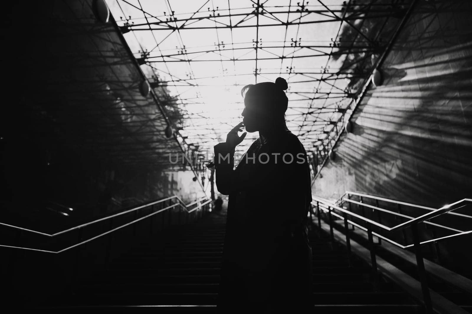 Portrait of a young Asian woman posing in the subway near the stairs. by mrwed54