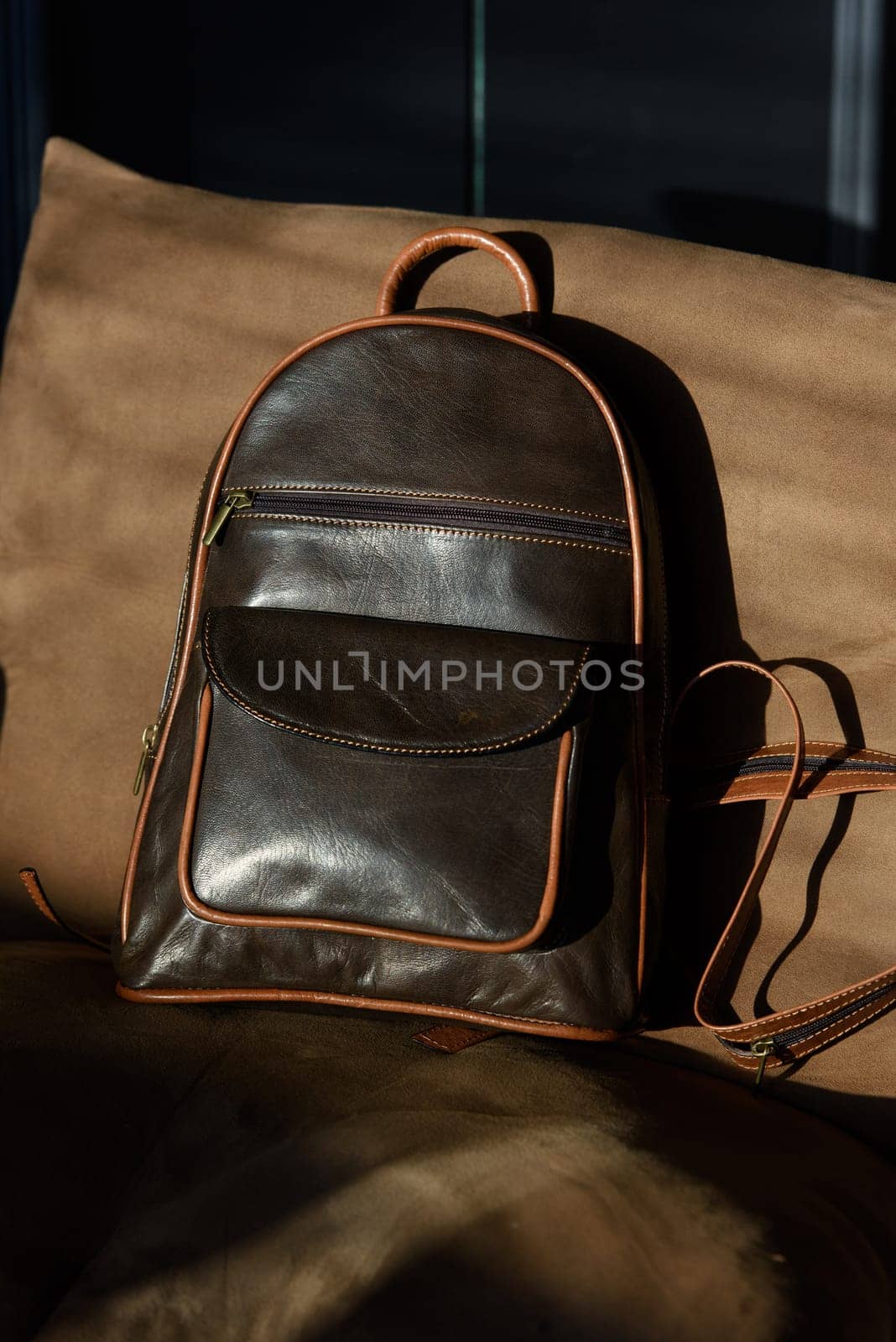 Brown leather backpack on chair, close up. by Ashtray25