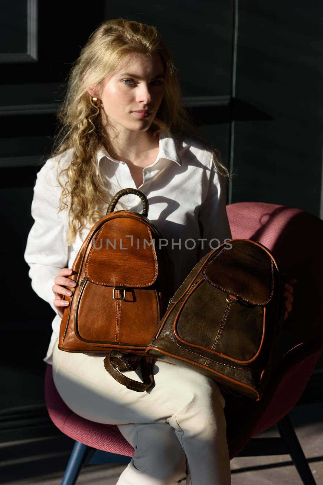 beautiful curly blond hair woman posing with a two leather backpacks by Ashtray25