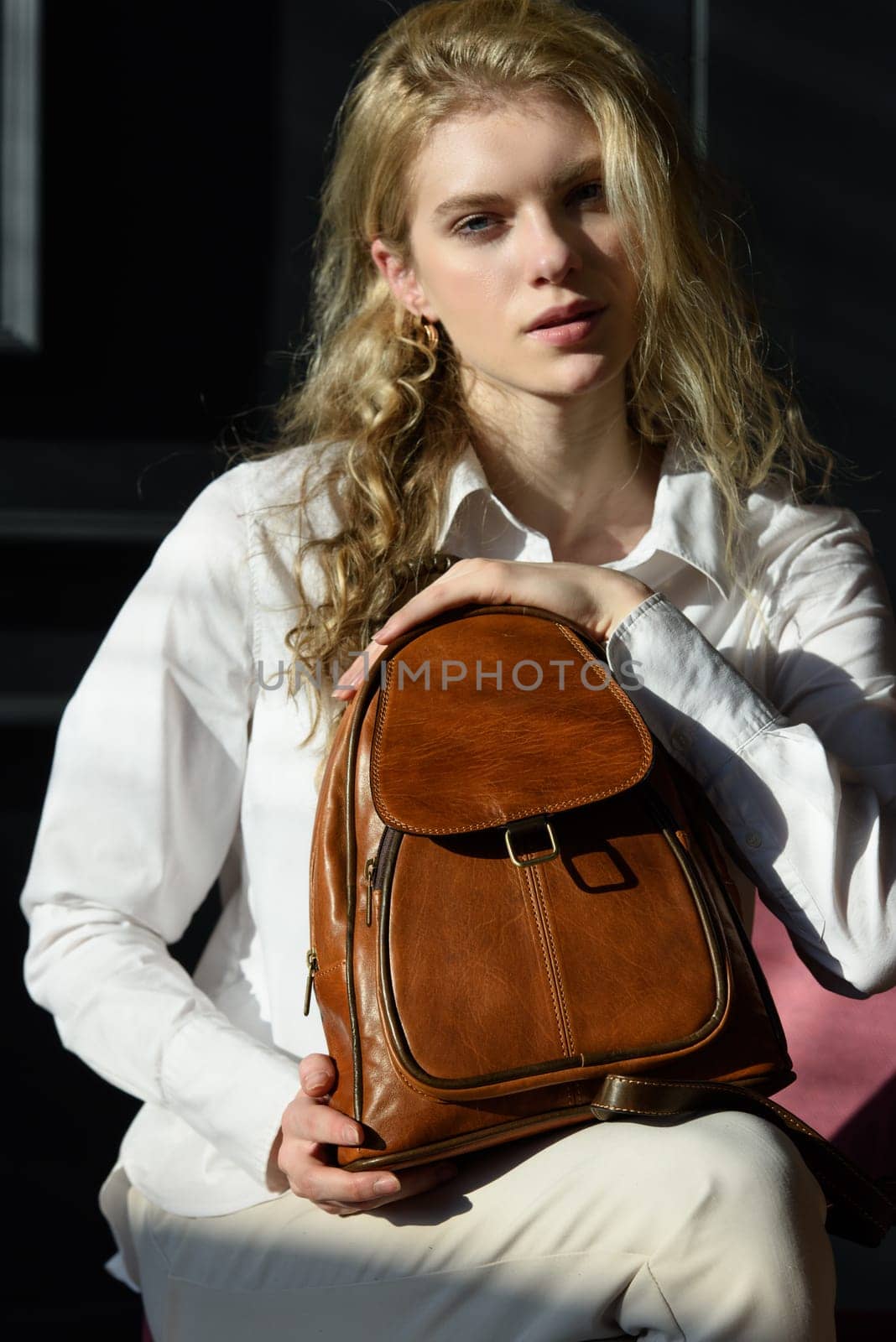 beautiful curly blond hair woman posing with a leather backpack by Ashtray25