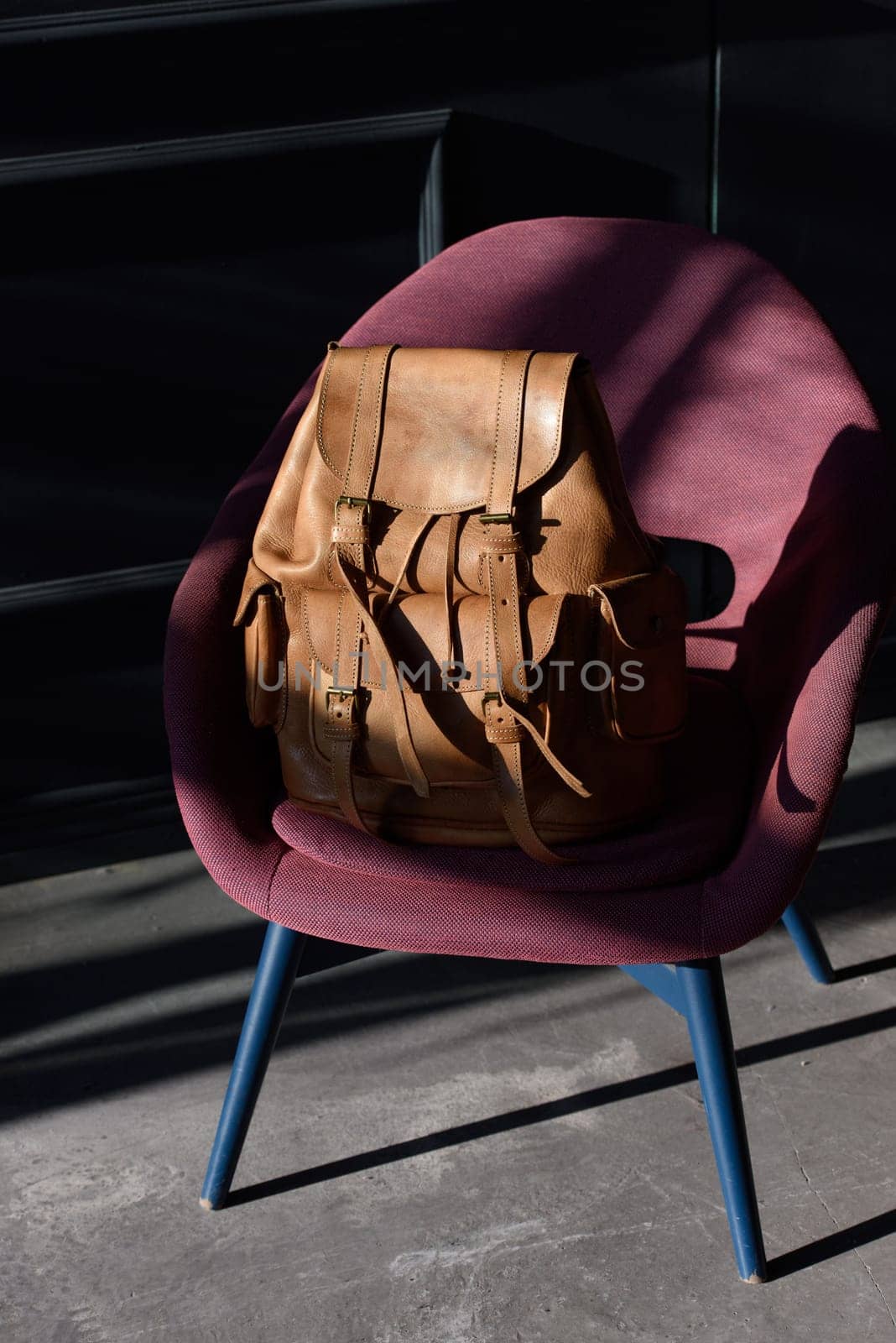 Brown leather backpack on chair, close up. by Ashtray25