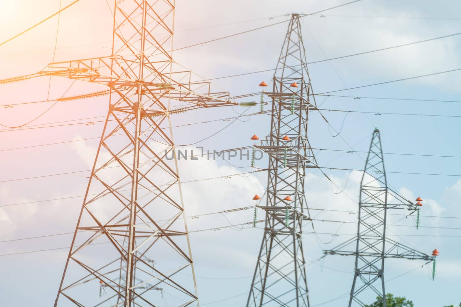 High voltage towers with sky background. Power line support with wires for electricity transmission. High voltage grid tower with wire cable at distribution station. Energy industry, energy saving.