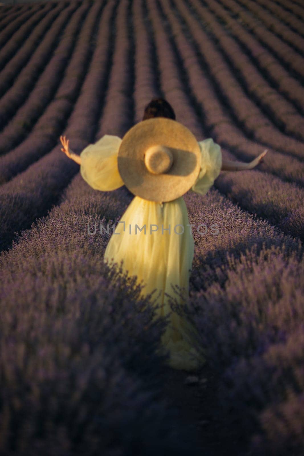 Woman lavender field sunset. Back view woman in yellow dress and hat. Aromatherapy concept, lavender oil, photo session in lavender by Matiunina