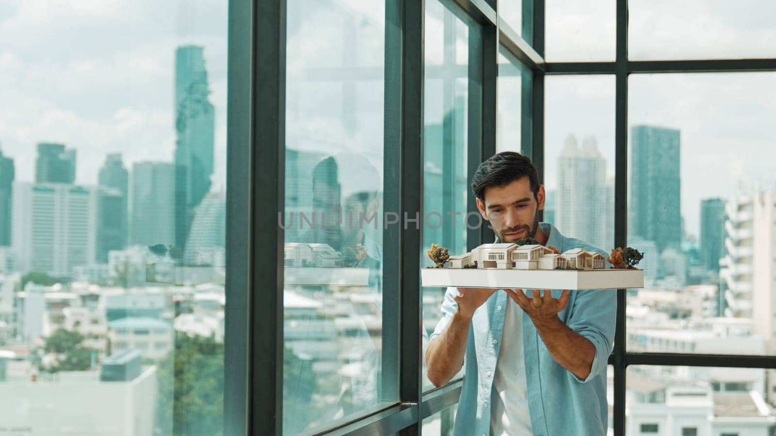 Businessman holding house model while checking house construction. Tracery by biancoblue