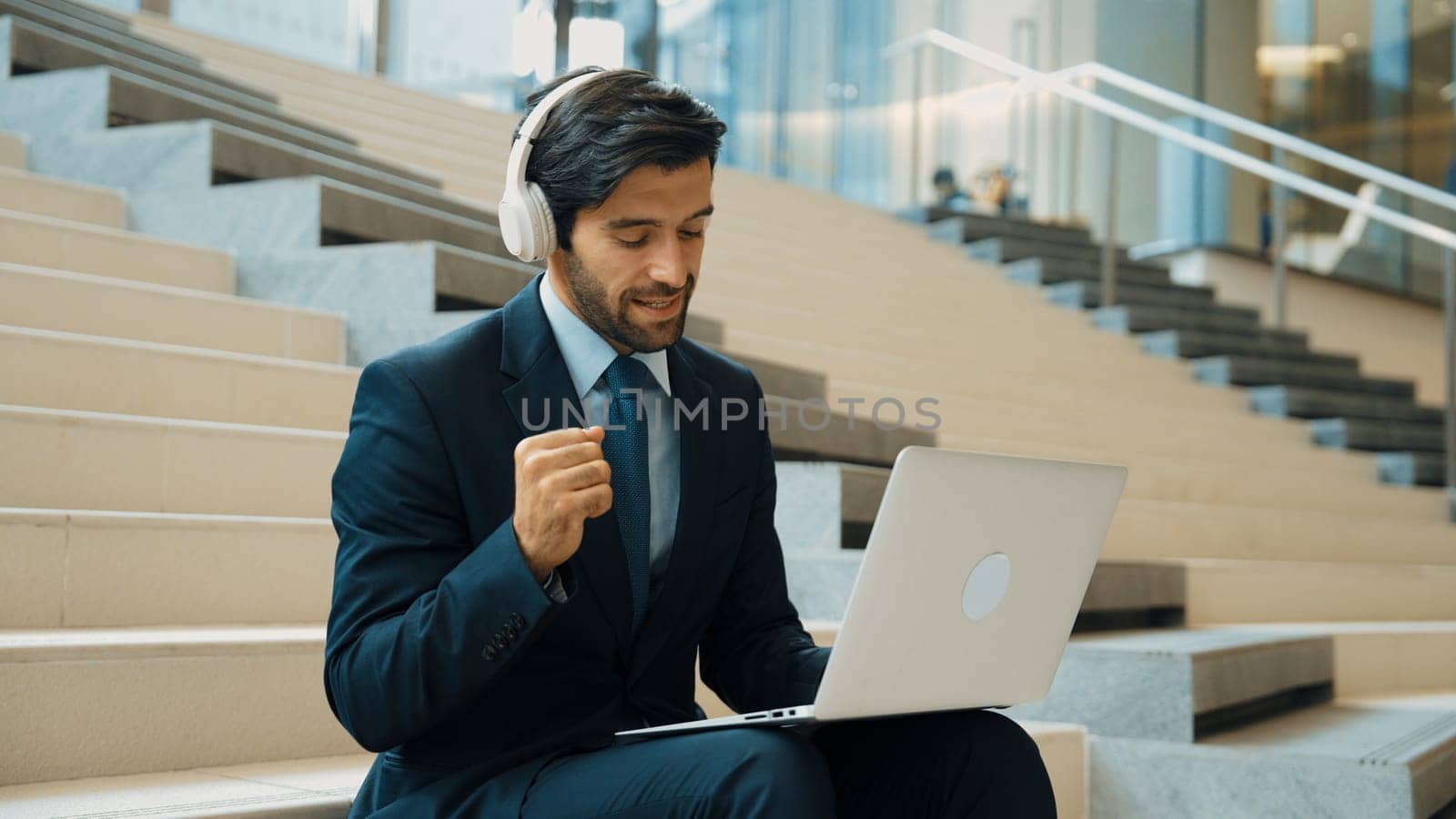 Confident business man celebrate successful idea while listen music. Exultant. by biancoblue