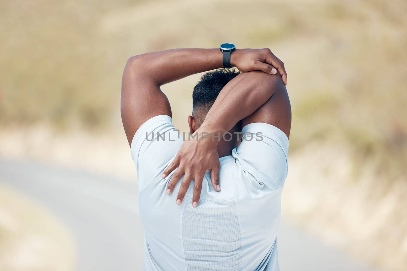 Man, back and stretching with fitness in road for preparation, workout or outdoor exercise. Rear view of male person or athlete in body warm up or getting ready for training or mountain run on street.