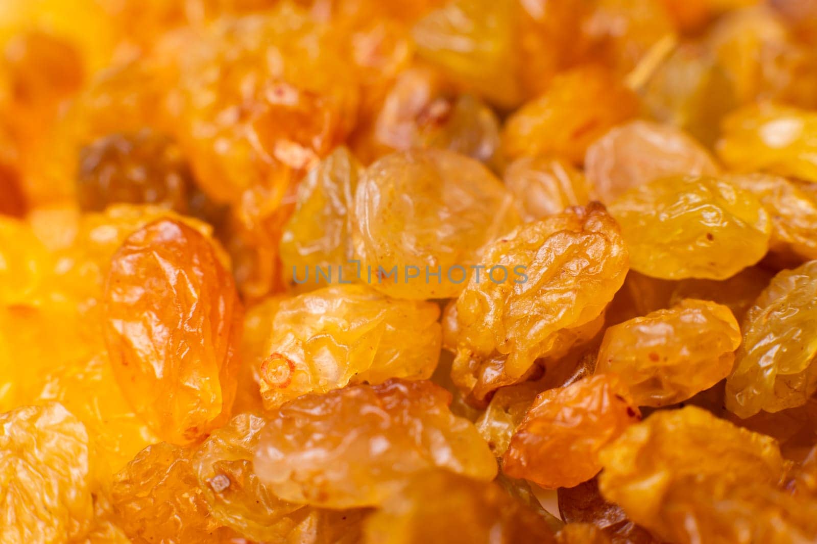Background of a large number of dried yellow golden grapes. Raisin. Vegetarian diet.